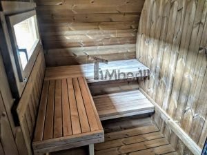 TimberIN Nordic Oval™ Terrace – interior: bancos de madera en dos niveles bajo una pequeña ventana, paredes curvas revestidas de madera