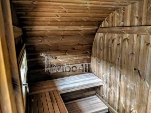 TimberIN Nordic Oval™ Terrace – interior: bancos de madera en dos niveles bajo una pequeña ventana, paredes curvas revestidas de madera
