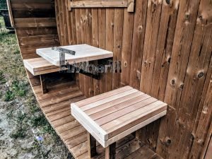 TimberIN Nordic Oval™ Terrace – asientos abatibles y mesita de madera clara sobre el suelo del porche de madera termotratada