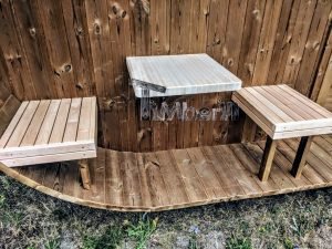TimberIN Nordic Oval™ Terrace – asientos abatibles y mesita de madera clara sobre el suelo del porche de madera termotratada