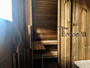 TimberIN Nordic Oval™ Terrace – interior: puerta de cristal y bancos de madera, paredes revestidas de madera