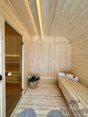 Interior de la sauna Nordic Horizon con madera clara, techo curvado y bancos