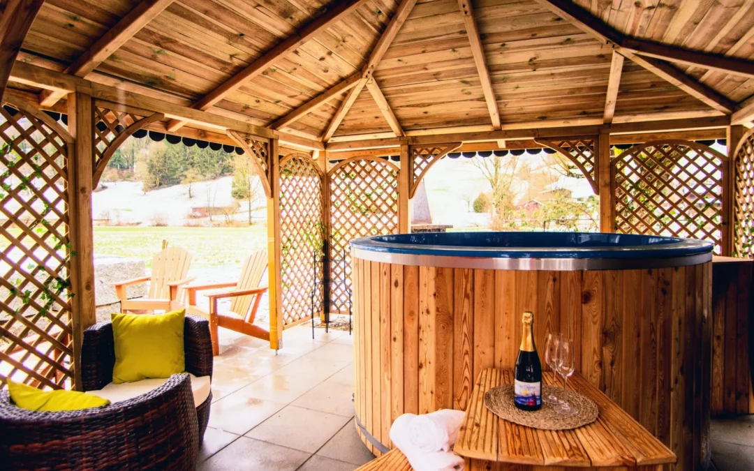 Jacuzzi con revestimiento de madera bajo un pabellón de madera