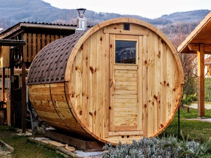 Sauna barril de abeto con puerta de cristal en un jardín