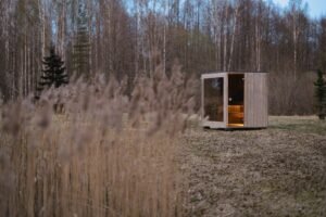 Sauna de exterior TimberIN Nordic Cube de CLT a orillas de un lago