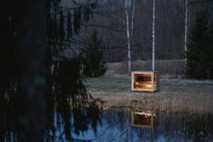 Sauna de exterior TimberIN Nordic Cube de CLT en un prado